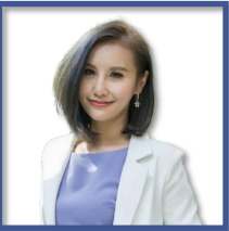 A woman with straight shoulder-length hair, wearing a light blue top and white blazer, smiling in front of a plain white background