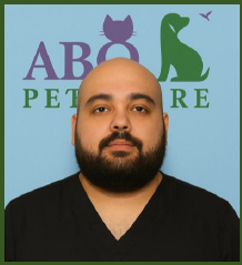 A man with a beard wearing black scrubs, standing in front of a light blue background with the logo 'ABQ Pet Care' featuring a cat and dog graphic.