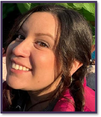 A woman with dark hair , with a braid, wearing a pink top, in a side view pose